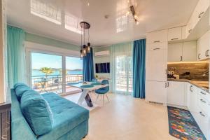 a living room with a blue couch and a table at Upper Deck Apt. in Nea Peramos