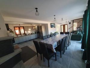 a dining room with a table and chairs and a kitchen at Cabana Gap House in Colţeşti