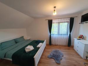 a bedroom with a green bed and a window at Cabana Gap House in Colţeşti