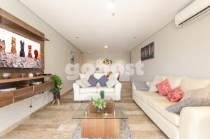 sala de estar con muebles blancos y pantalla grande en Spacious 2 Bedroom Apt In Villa Morra, en Asunción