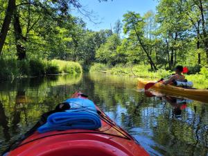 two people laying in a kayak on a river at PAKLADA Domek całoroczny 1 in Bak