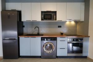 a kitchen with a refrigerator and a washing machine at Dabney3 Apartments in Madalena +15 photos