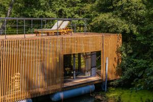 a wooden building with a bench on top of the water at Water Hideout - Floating Luxury in Pure Wilderness in Wysoka