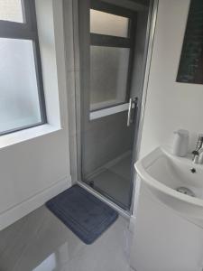 a shower with a glass door next to a sink at Blue house, Carraroe in Carraroe
