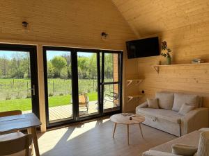 a living room with a couch and a tv and a table at PAKLADA Domek całoroczny 1 in Bak