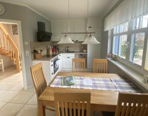 a kitchen with a wooden table and chairs at Ferienhaus Laran in Zingst
