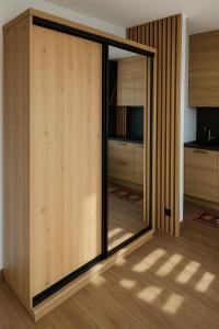 a pivot door in a room with wooden walls at Przytulny apartament Brooklyn Centrum miasta Rzeszów - Podwisłocze 38 in Rzeszów