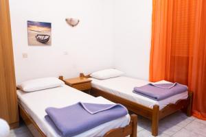 two beds in a room with purple towels on them at HOTEL PAVLOS in Paralia Katerinis