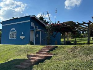 a blue house with stairs in front of it at Pousada Sonho do Campo in São Pedro