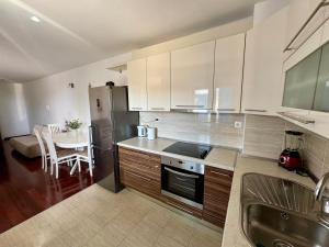 a kitchen with white cabinets and a small table with a table at Apartment on the beach Mare in Makarska +10 photos