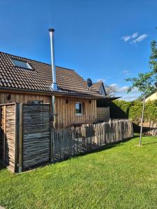 a house with a wooden fence in the yard at Ferienhäuschen Landleben pur in Much