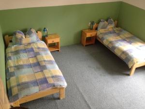 two beds in a room with green walls at Holiday house Mernye in Mernye