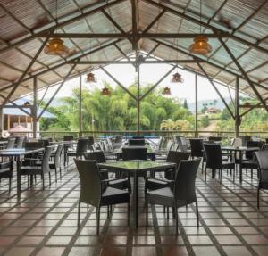 a restaurant with tables and chairs and a large window at Hotel Villa Mónaco in Pereira