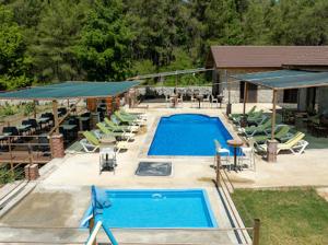 a large swimming pool with chairs and a building at Sora no mori in Marmaris