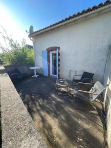 a group of chairs sitting outside of a building at Maison au calme , proche du parc du PDF in Pouzauges