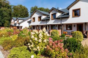 a house with a garden of flowers at APARTAMENTY STARE SARBINOWO in Sarbinowo