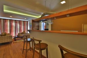 a living room with a bar with chairs and a couch at Lemas Holiday Bungalow in Nuwara Eliya