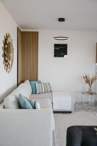 un salon blanc avec un canapé blanc dans l'établissement Lili Rose Mandre - Exclusive Family Apartments with Sea View, Just Steps from Beach, à Mandre