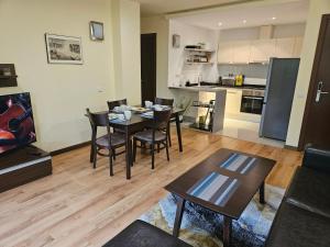 un salon avec une table et des chaises et une cuisine dans l'établissement TERRA COMPLEX B4 - Private apartment - Golf, Skiing & SPA, à Bansko