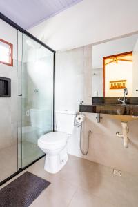 a bathroom with a toilet and a glass shower at Espaço inteiro:piscina aquecimento solar,2 suítes in Pirenópolis +23 photos