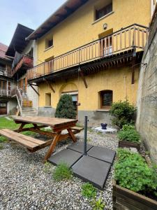 drewniany stół piknikowy przed budynkiem w obiekcie Maison 100m2 - 3 chambres w mieście Villar-Saint-Pancrace