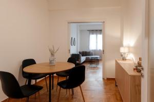 a dining room with a table and black chairs at Athens Ivy Residence By Staycom in Athens
