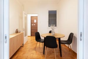 a dining room with a table and black chairs at Athens Ivy Residence By Staycom in Athens