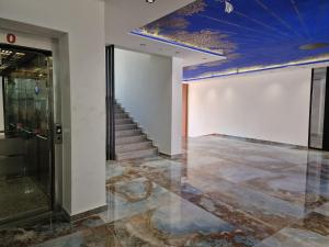 a lobby with a blue ceiling and a staircase at AURORA Apartment Shëngjin Kune in Shëngjin