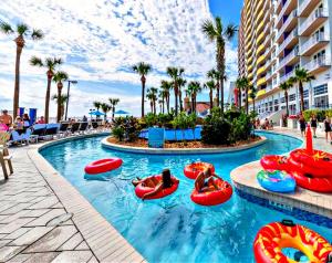 een zwembad in een resort met mensen in opblaasbare baden bij Wyndham Ocean Walk Resort -7th Floor 2 BR Direct Oceanfront Condo 3 Balcony's in Daytona Beach +22 foto's