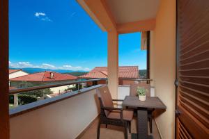 a balcony with a table and chairs and a view at Apartments Omanović in Čižići