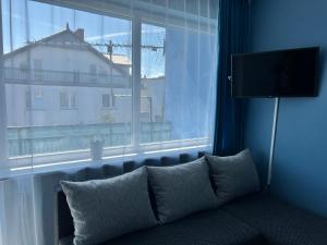 a couch in a room with a large window at Blue Mielno - Dom Gościnny in Mielno