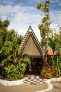 a house with a triangular roof in a garden at The Shady Rest Hotel in Port Moresby
