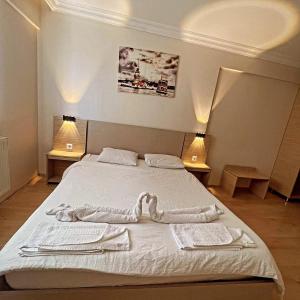 a bedroom with a large bed with two lamps at VB Otel in Kumartaş