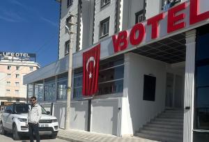 a man is standing in front of a store at VB Otel in Kumartaş