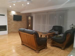 salon ze skórzanymi krzesłami i stołem w obiekcie Willa Ola w mieście Nadole
