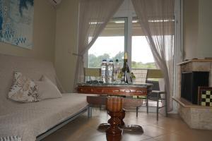 a living room with a couch and a table with bottles on it at ELENI'S HOUSE in Nea Fokea