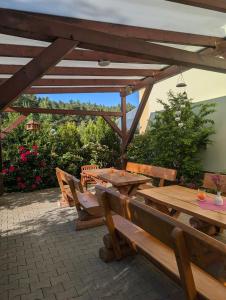 a wooden table and chairs under a wooden pergola at Pension zum Reiterhof, Fewo 2 in Schmogrow
