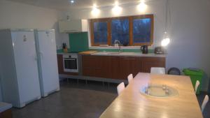a kitchen with a wooden table and a white refrigerator at Family holiday home - very close to sandy beach in Gorey