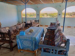 a room with a table and chairs and windows at Abo Orabi Guest House in Aswan