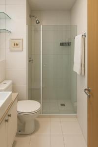 a bathroom with a toilet and a glass shower at Flat Vista Mar com Piscina e Wi-Fi Rápido Rio Vermelho in Salvador