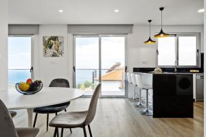 a kitchen and dining room with a table and chairs at Villa Vellure by Homie in Funchal
