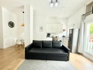 czarna kanapa w salonie z kuchnią w obiekcie Aluche Aparment B w Madrycie +22 zdjęcia