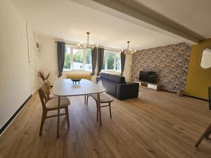 a living room with a table and a couch at L'Arena - Le Woody in Liévin