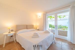 una camera da letto con un letto e una grande finestra di Prestigiosa Villa di Lusso con Vista Mozzafiato a Porto Cervo Altre 51 foto