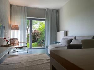 ein Wohnzimmer mit Couch und großem Fenster in der Unterkunft Idyllischer Hof mit 5 Wohnungen nahe des Saaler Boddens in Saal