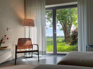 ein Schlafzimmer mit einem Stuhl und einem großen Fenster in der Unterkunft Idyllischer Hof mit 5 Wohnungen nahe des Saaler Boddens in Saal