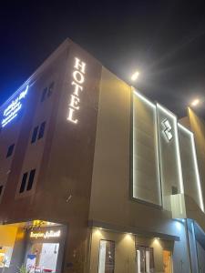 Un edificio con un letrero de neón en el costado. en أبها ريجنسي Abha Regency, en Abha