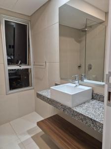 a bathroom with a white sink and a window at Molas Tower 119D in Asunción +10 photos