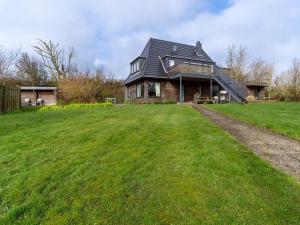 a house with a large grassy field in front of it at Ferienwohnung für 4 in Vollerwiek in Vollerwiek