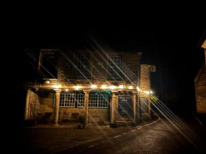 a brick building with lights on it at night at Bear Inn in Bisley